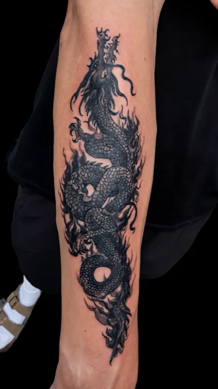 Dragon in flames — Japanese blackwork tattoo on forearm