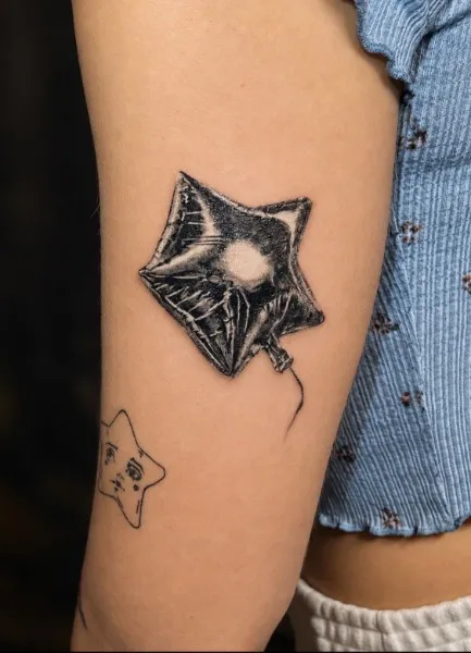 Mylar star balloon — Black & gray realism tattoo on upper arm